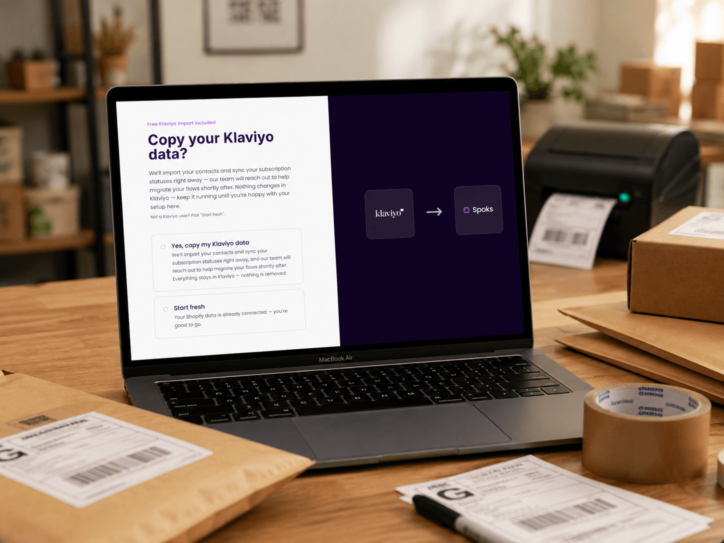 The Spoks onboarding screen open on a laptop at a Shopify packing desk, prompting the merchant to copy their Klaviyo data